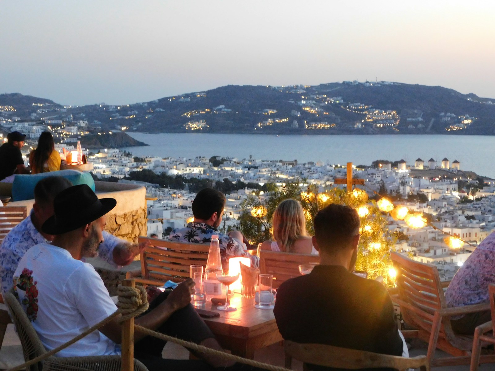 people sitting on chair in front of table with candles on top of it during night